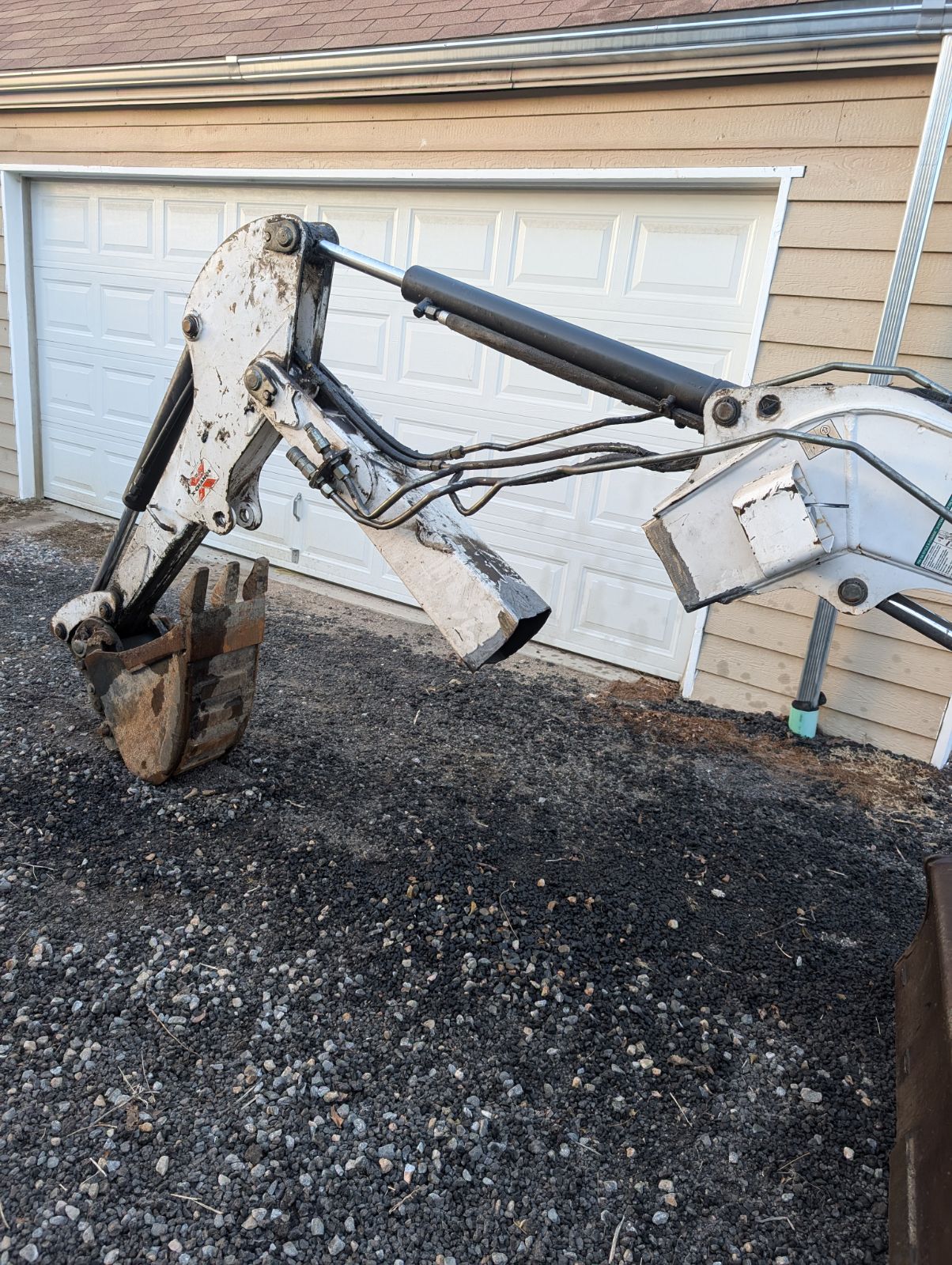 Backhoe arm and bucket weld repair at shop