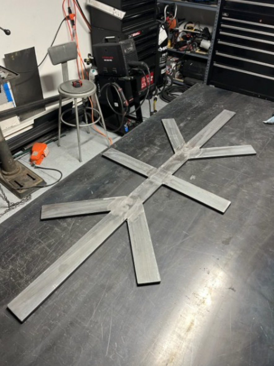 Custom welded steel X-frame table base on shop table
