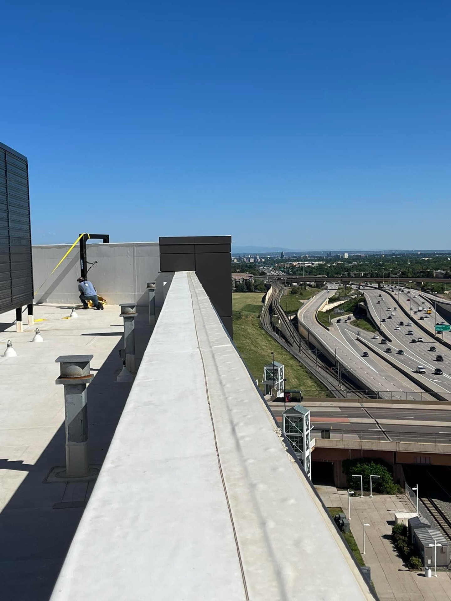 Rooftop steel welding work overlooking Denver skyline and I-25