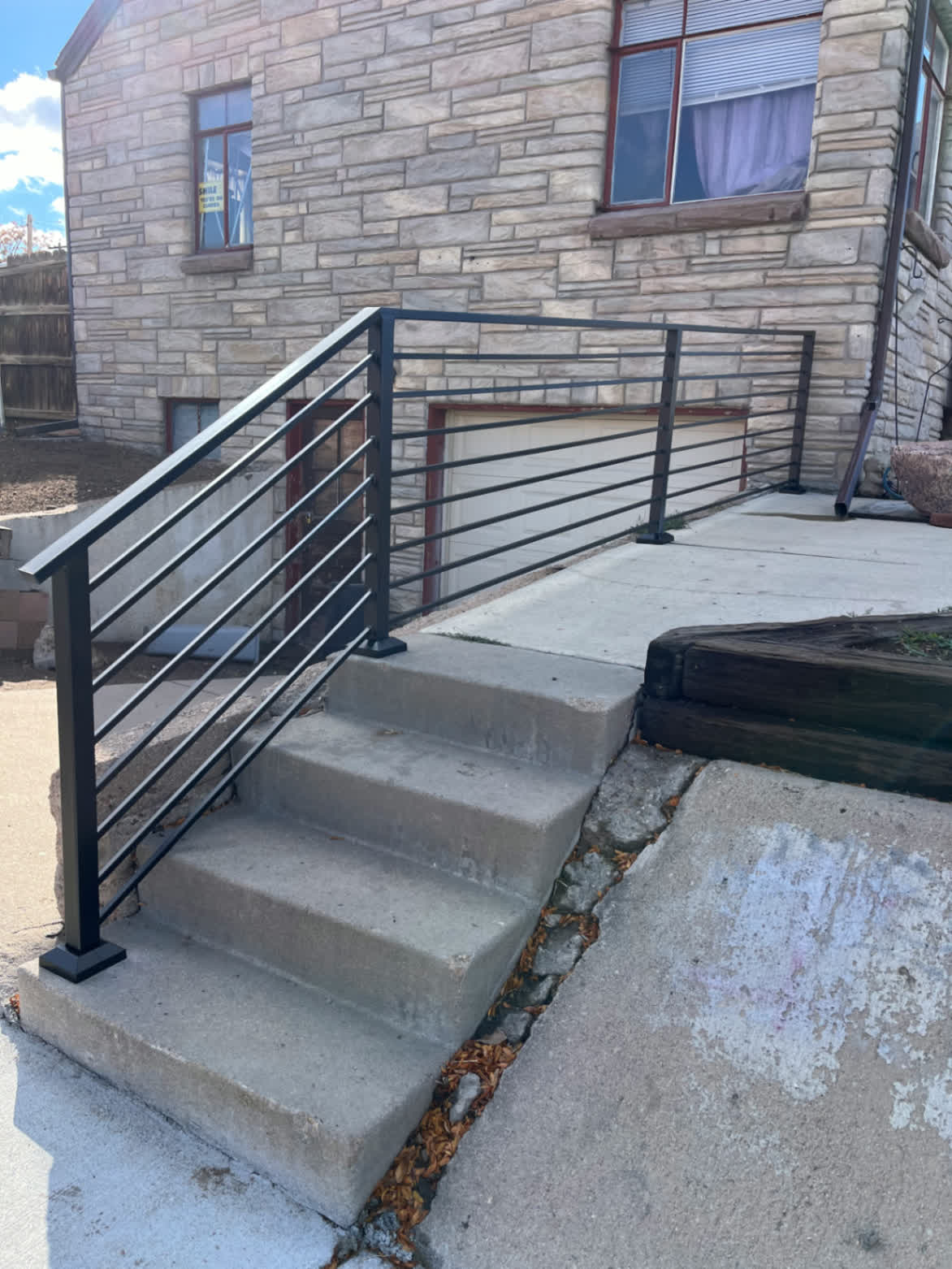 Horizontal-bar steel railing on stone home entry steps