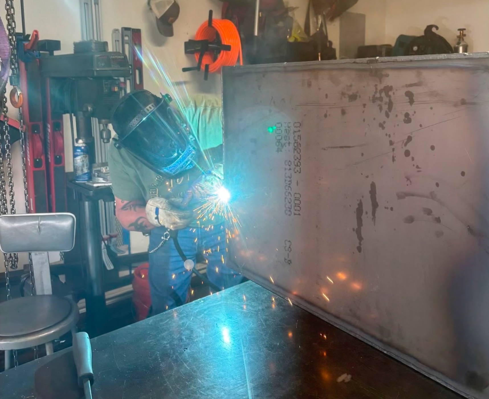 TIG welding heavy steel tank seam in the shop with bright arc