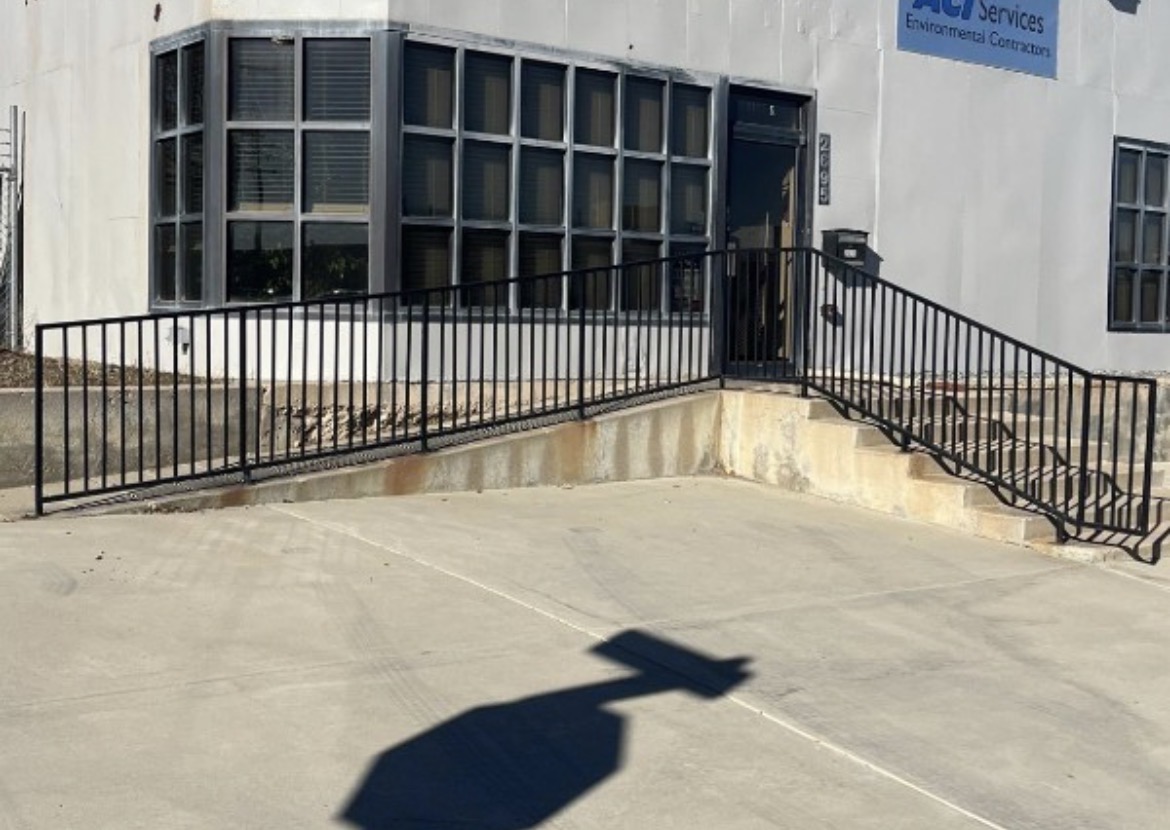 Long steel handrail along commercial ramp and stairs
