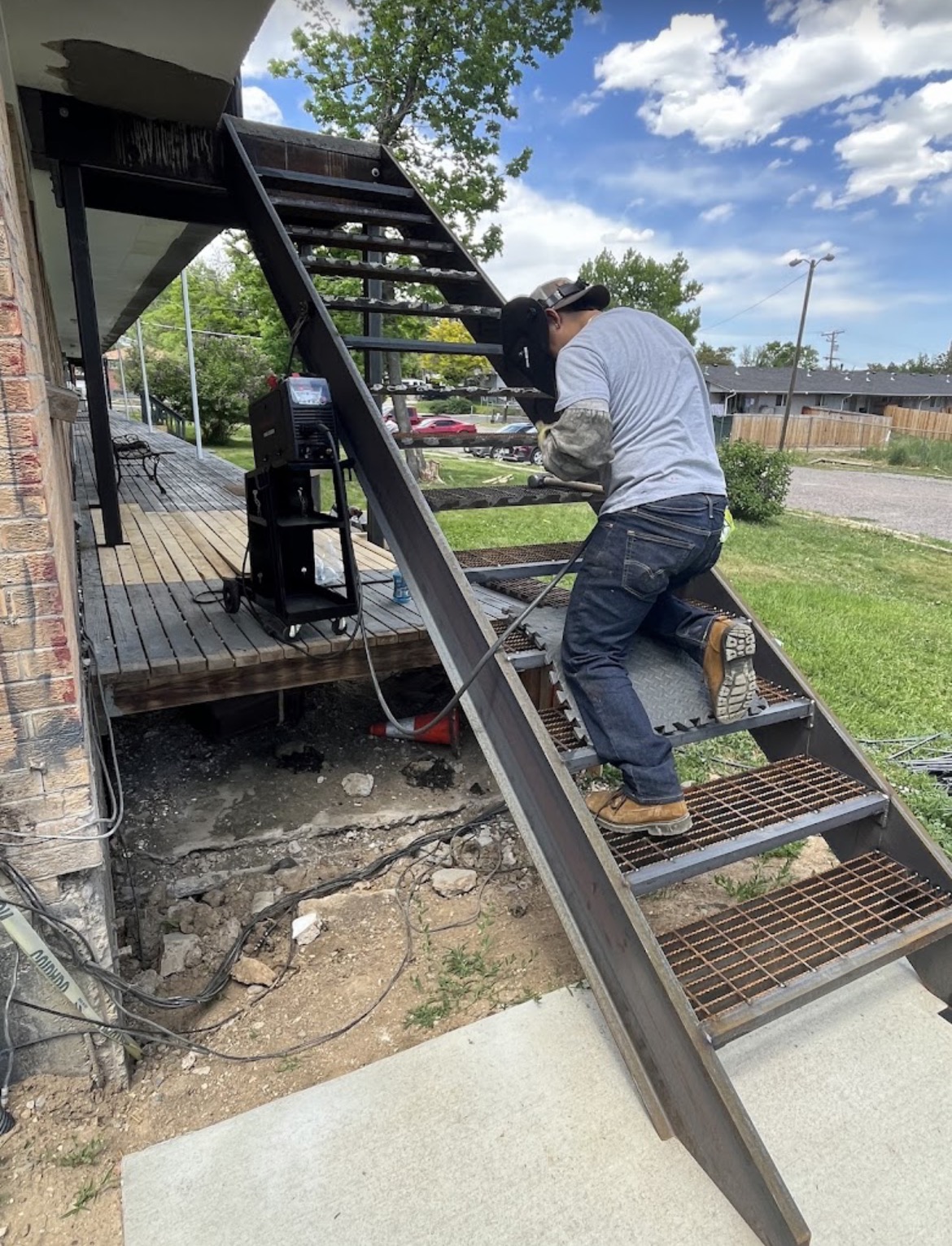 Welder installing custom steel exterior stairway