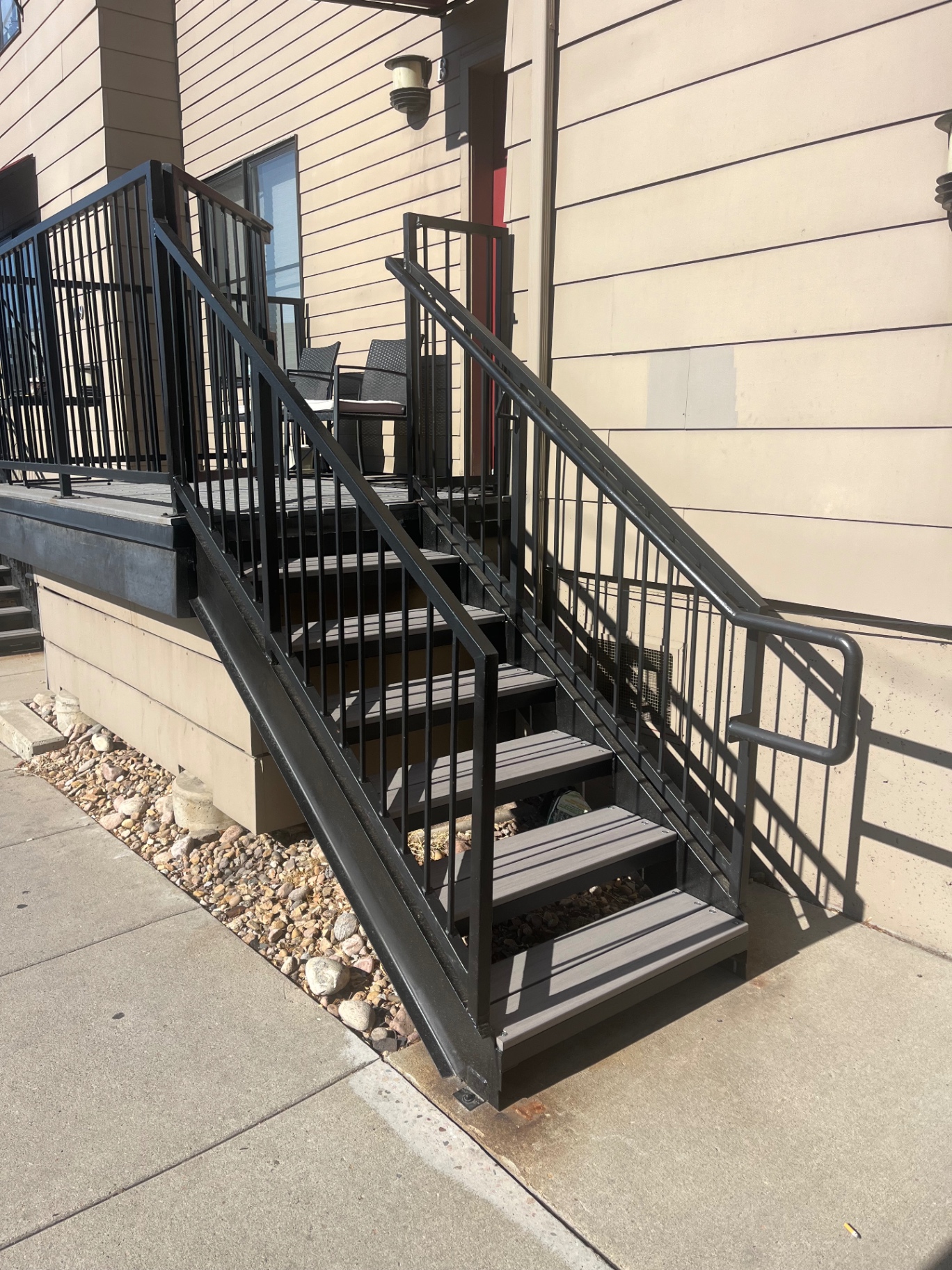 Black steel exterior stairs with landing and composite treads