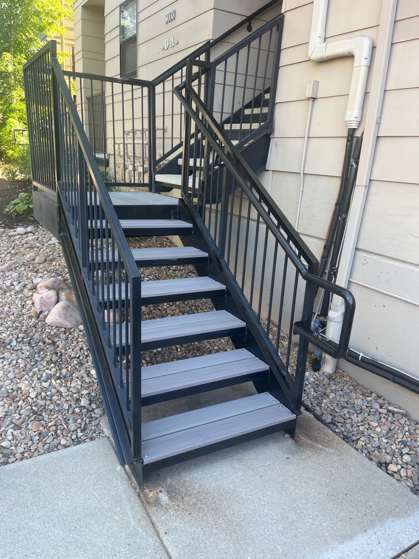Black steel exterior stairs with composite treads at townhome