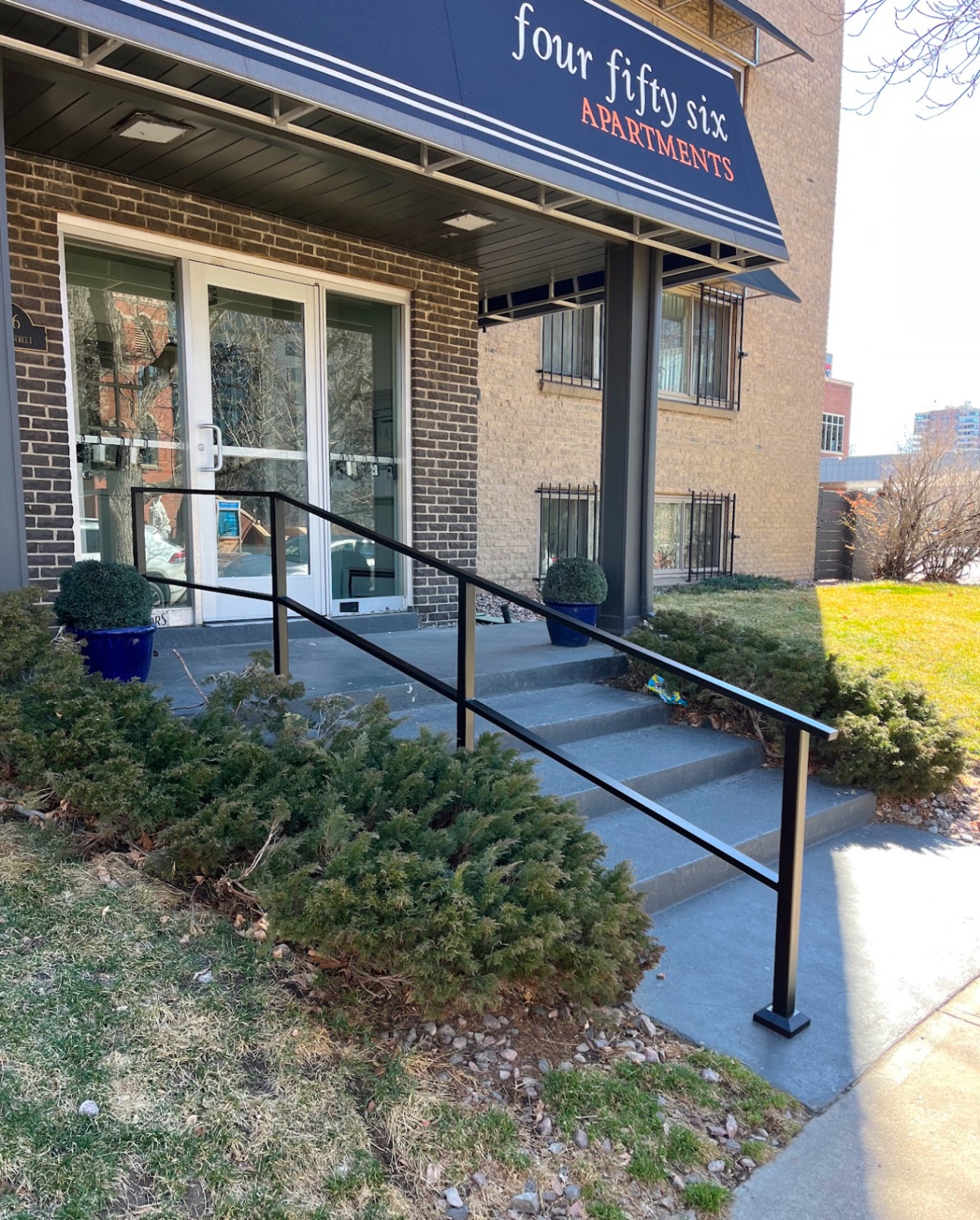 Black steel handrails on painted apartment entry steps