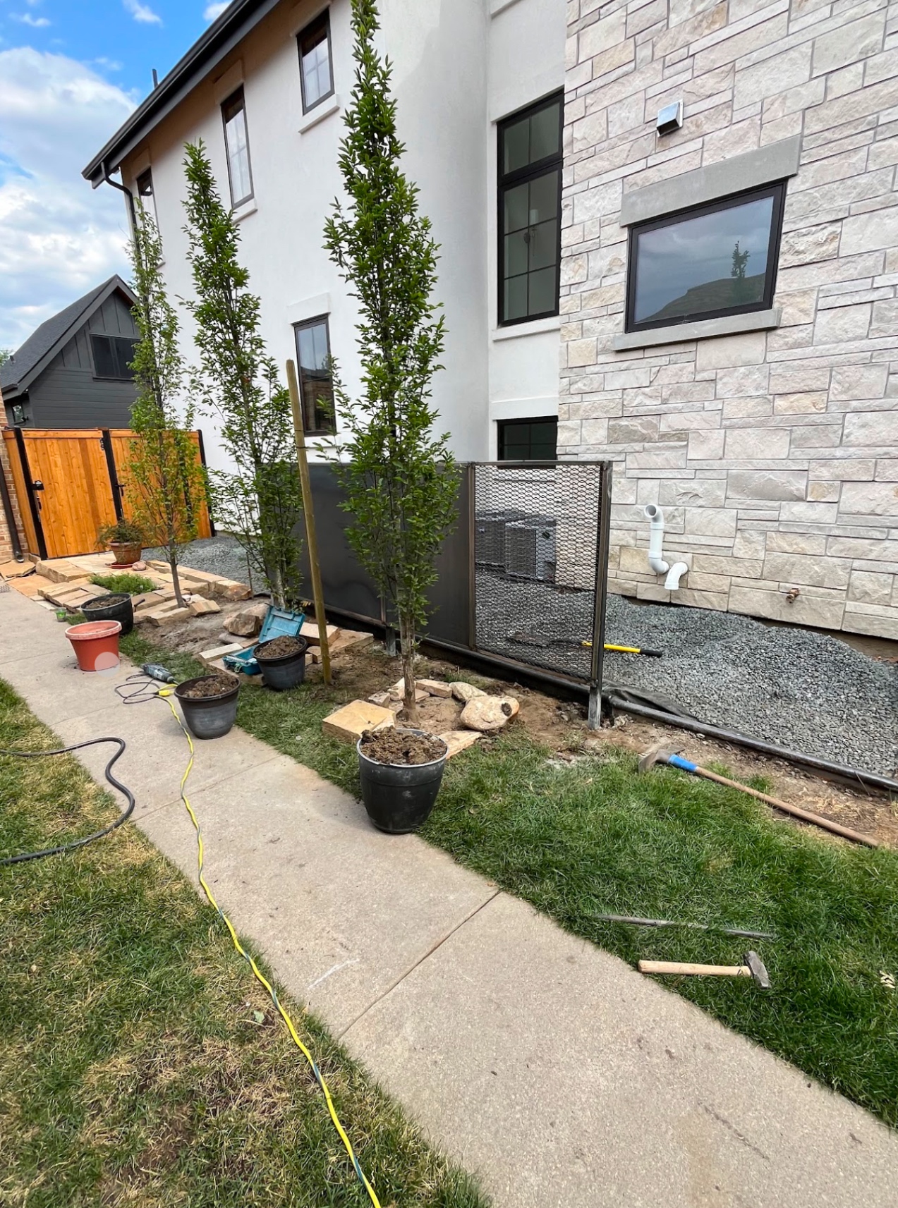 Steel AC condenser screen enclosure at modern townhome exterior
