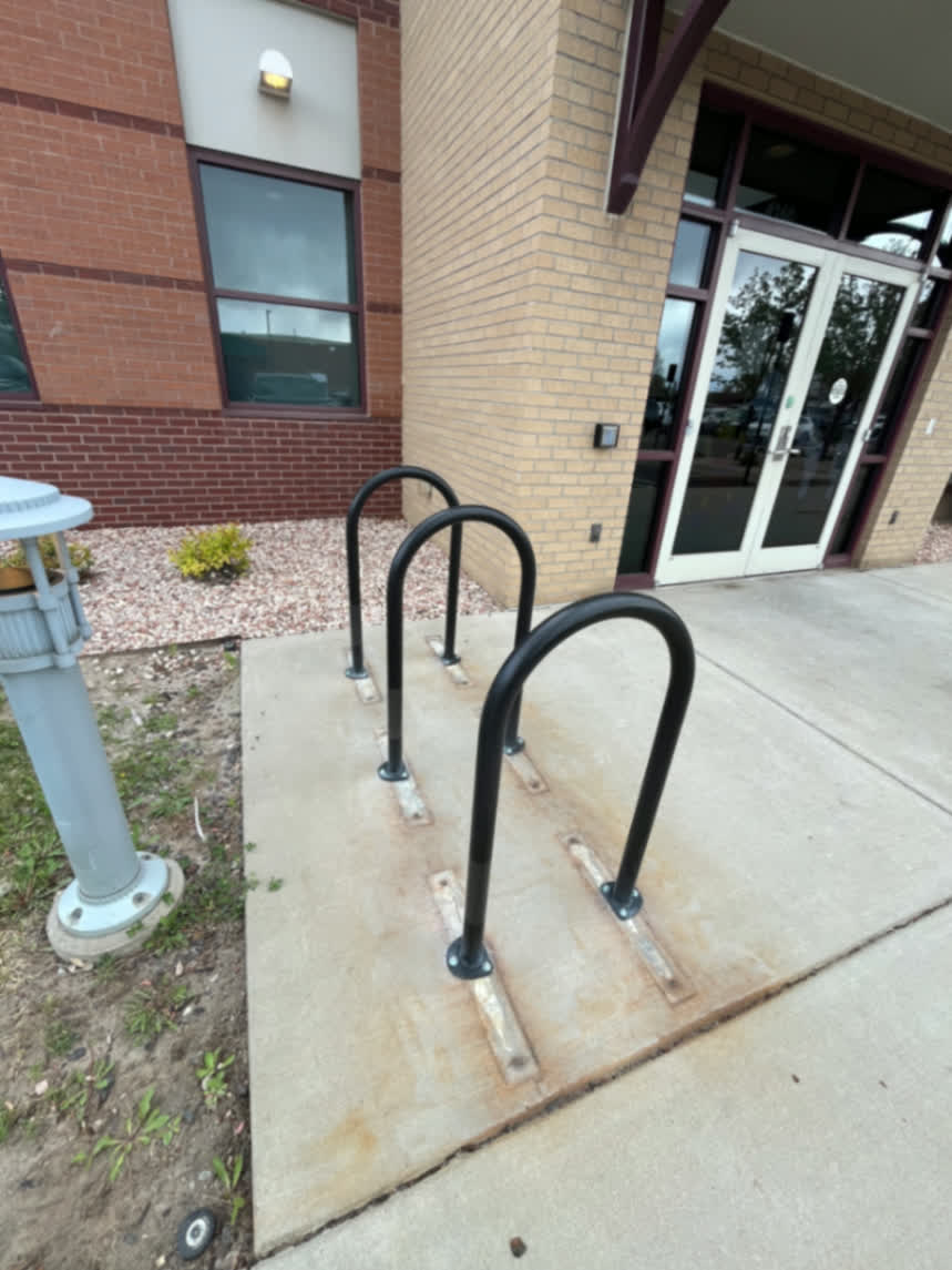 Custom black steel bike racks installed outside commercial building