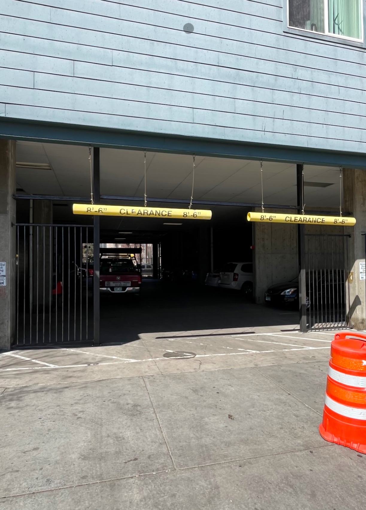 Yellow clearance bars and steel security gates at parking garage entrance