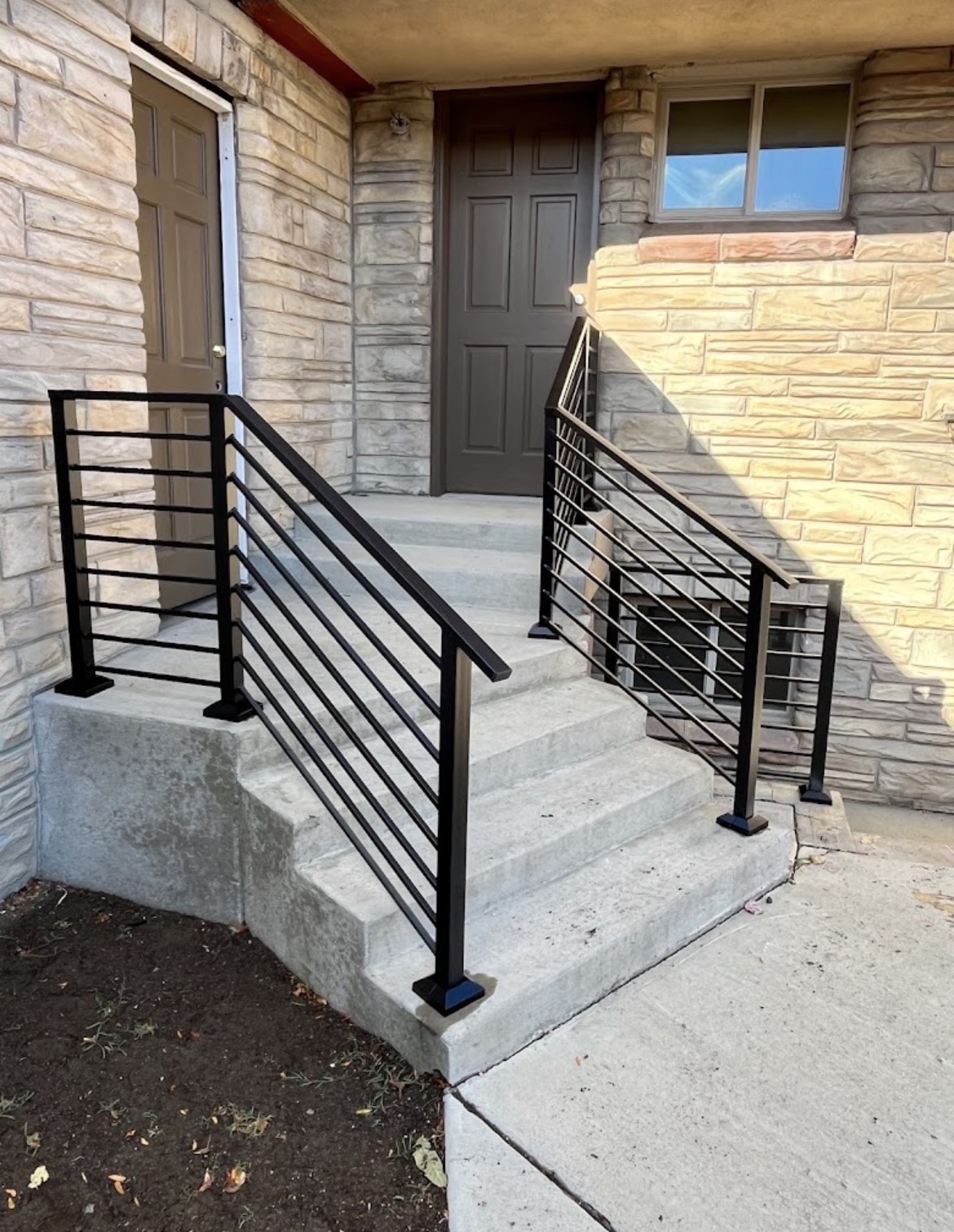 Horizontal-bar steel porch railings on stone home
