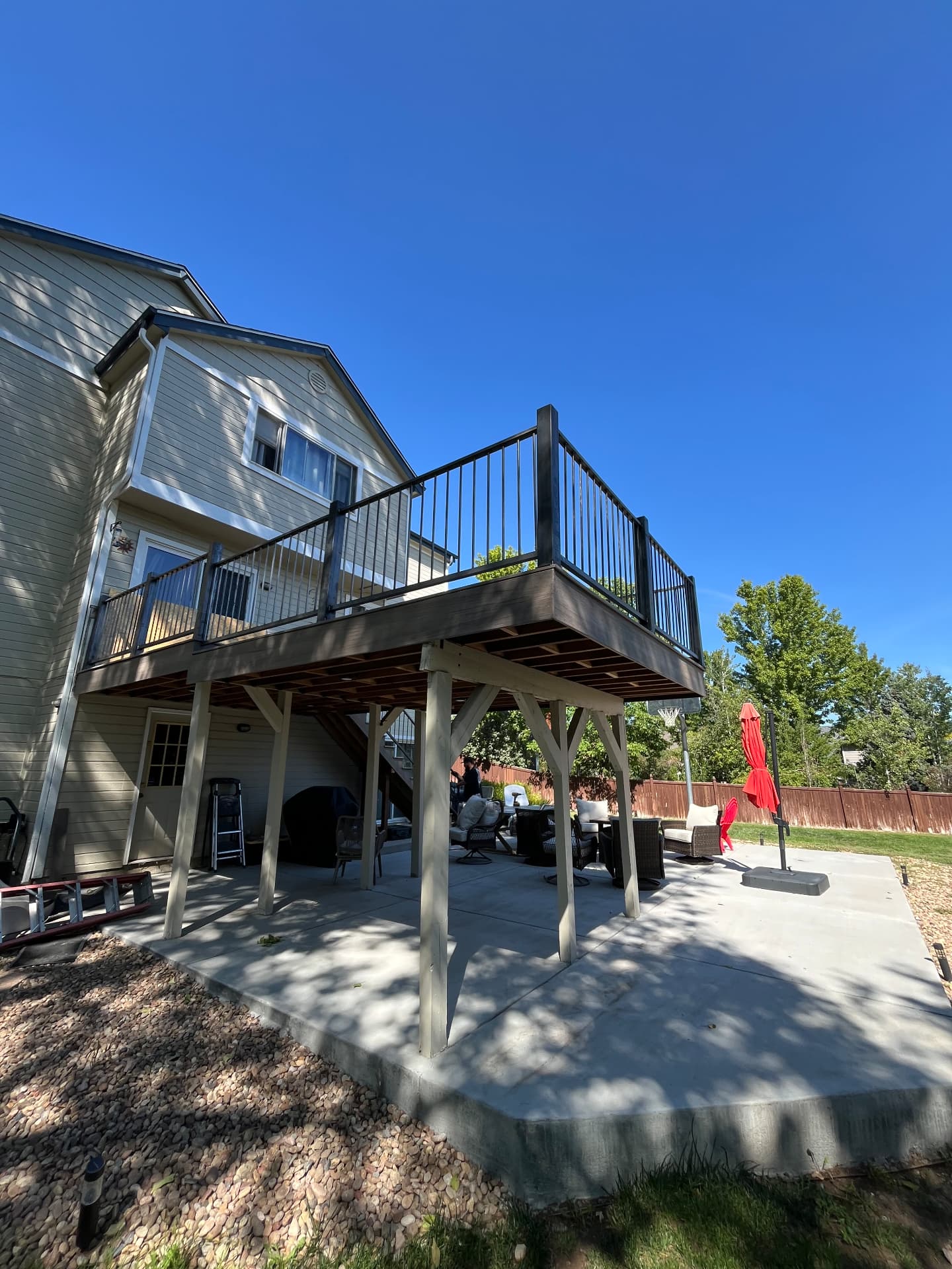 Black steel deck railing on elevated backyard composite deck