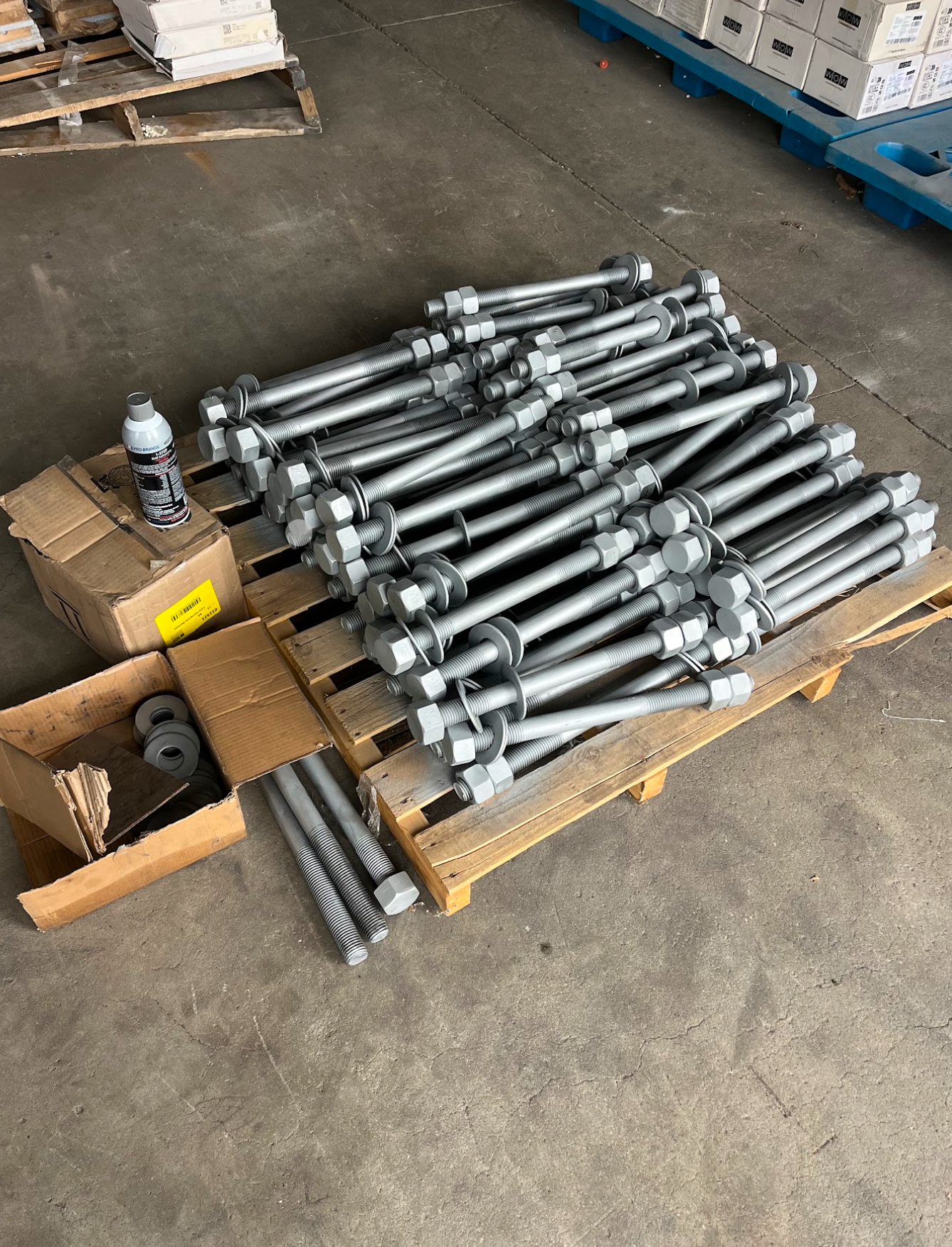 Galvanized structural anchor bolts staged on pallet for install
