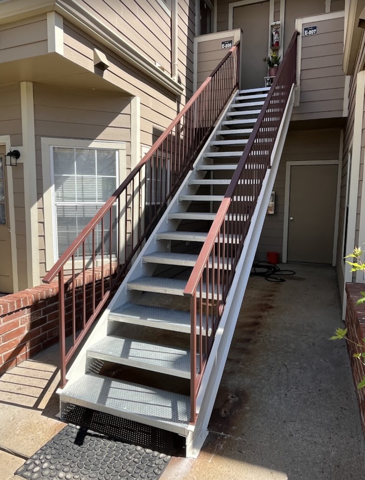 Tall apartment steel stairway with diamond-plate treads
