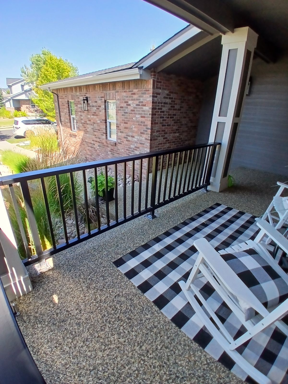 Black steel porch balcony railing at brick home