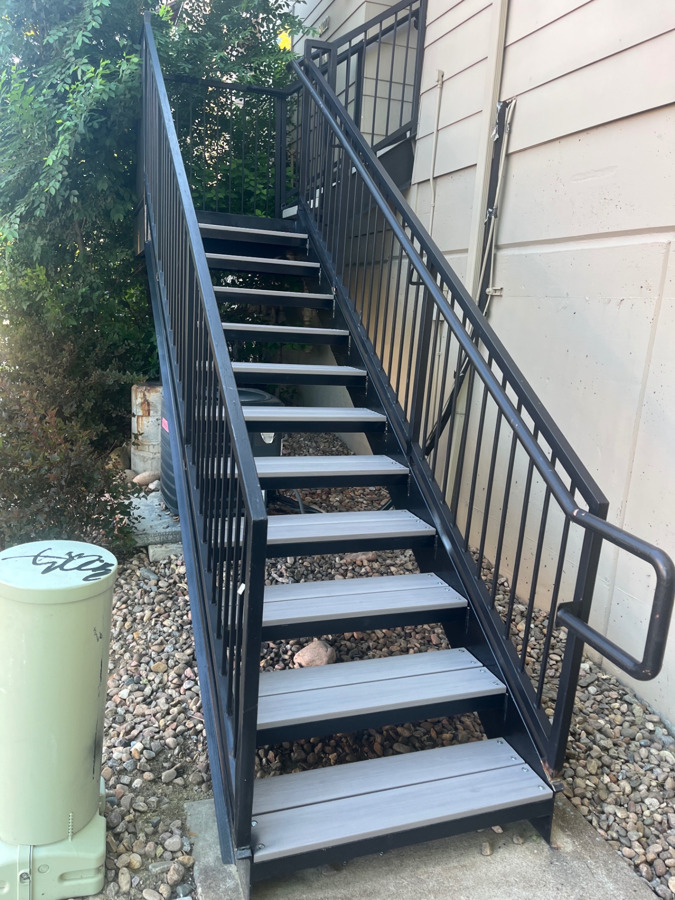 Steel exterior stairway with composite treads along siding