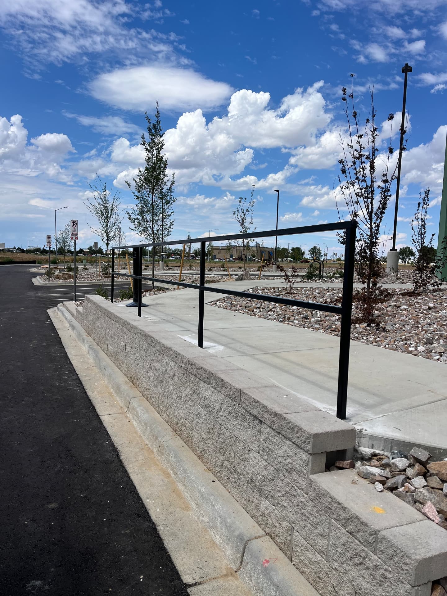 Black steel handrail and guardrail along commercial concrete ramp and walkway