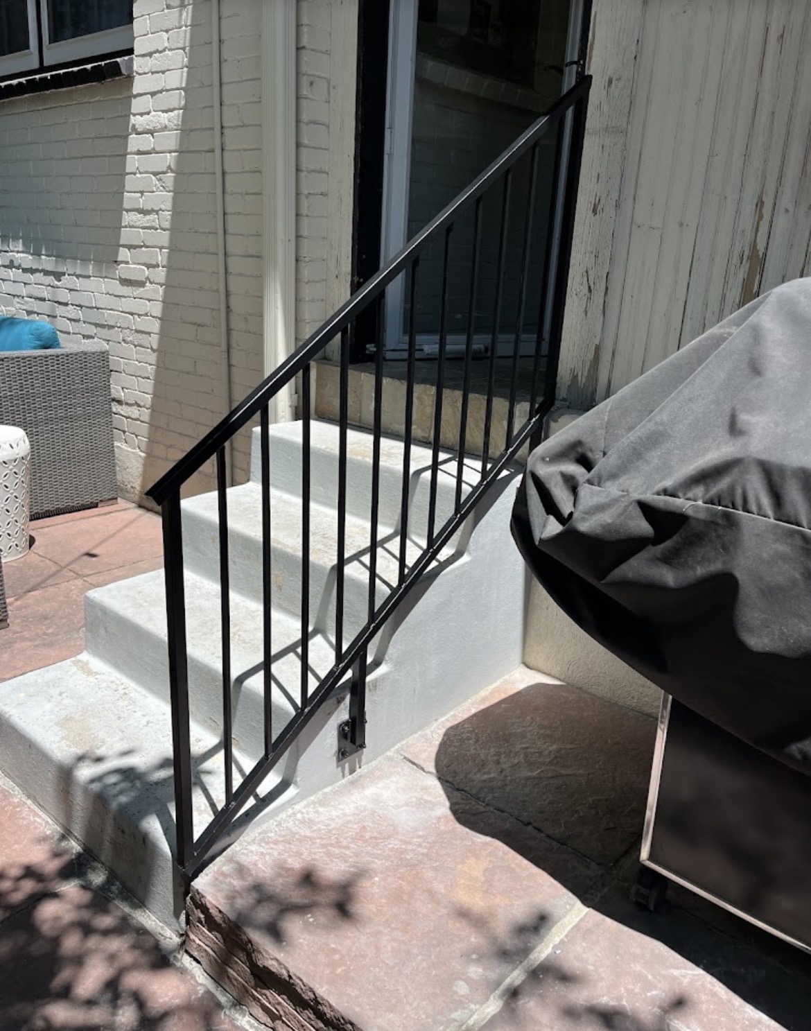 Black steel patio step railing at back door