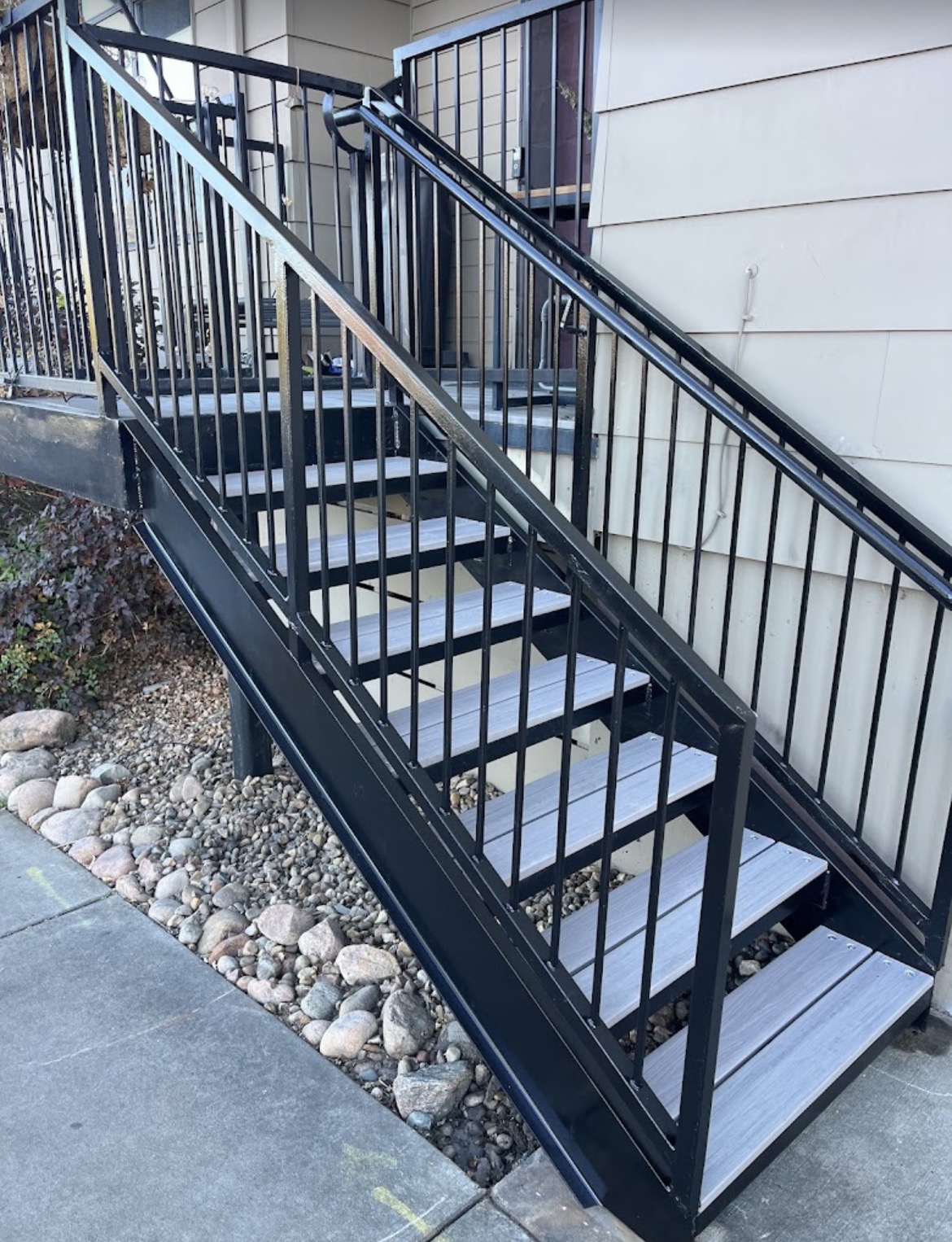 Black steel exterior step railing with composite treads