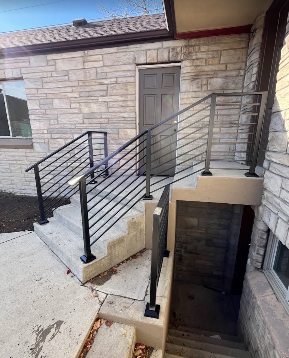 Modern horizontal steel railings on stone home entry