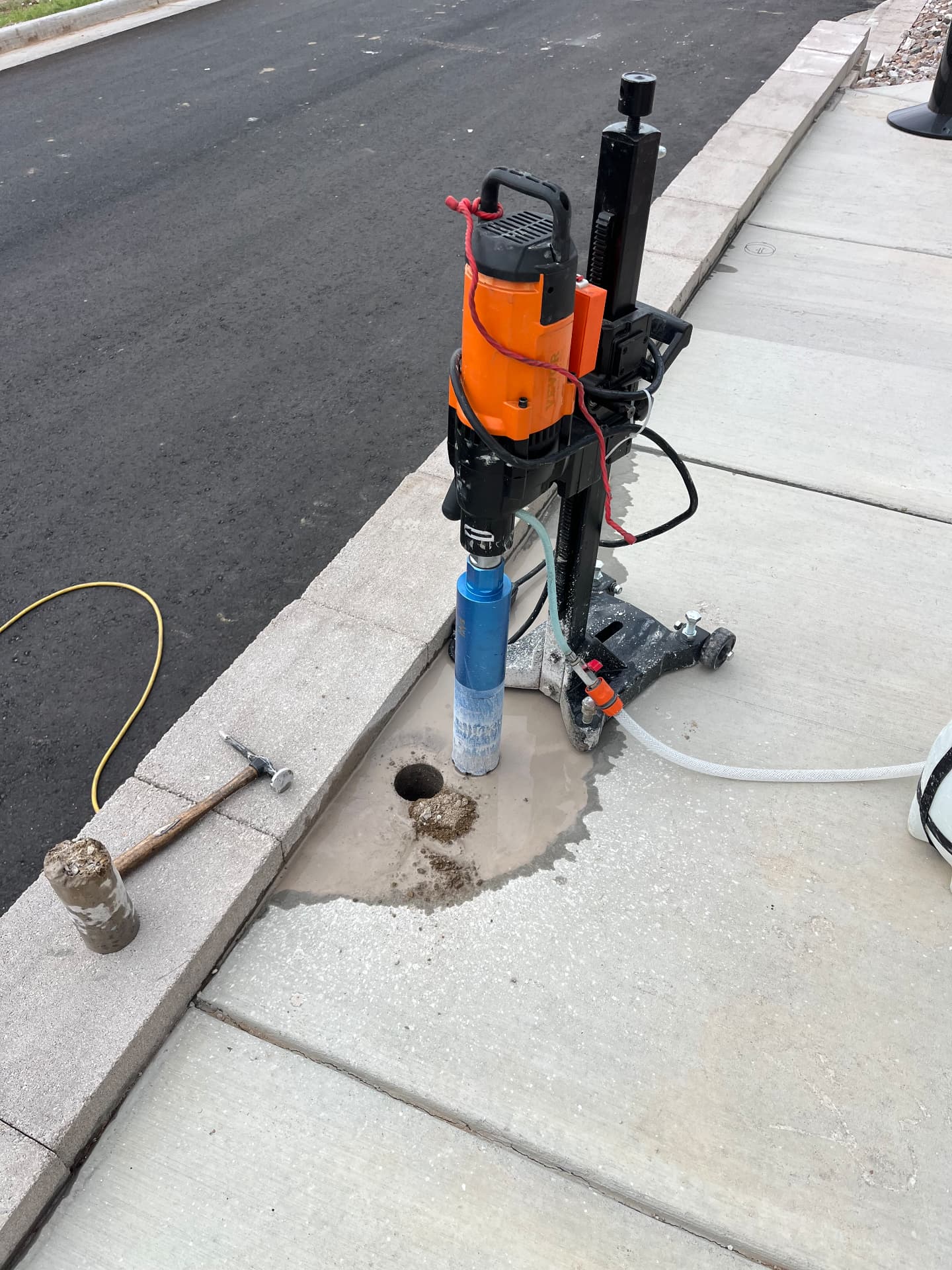 Core drill rig set up on concrete sidewalk for railing post installation