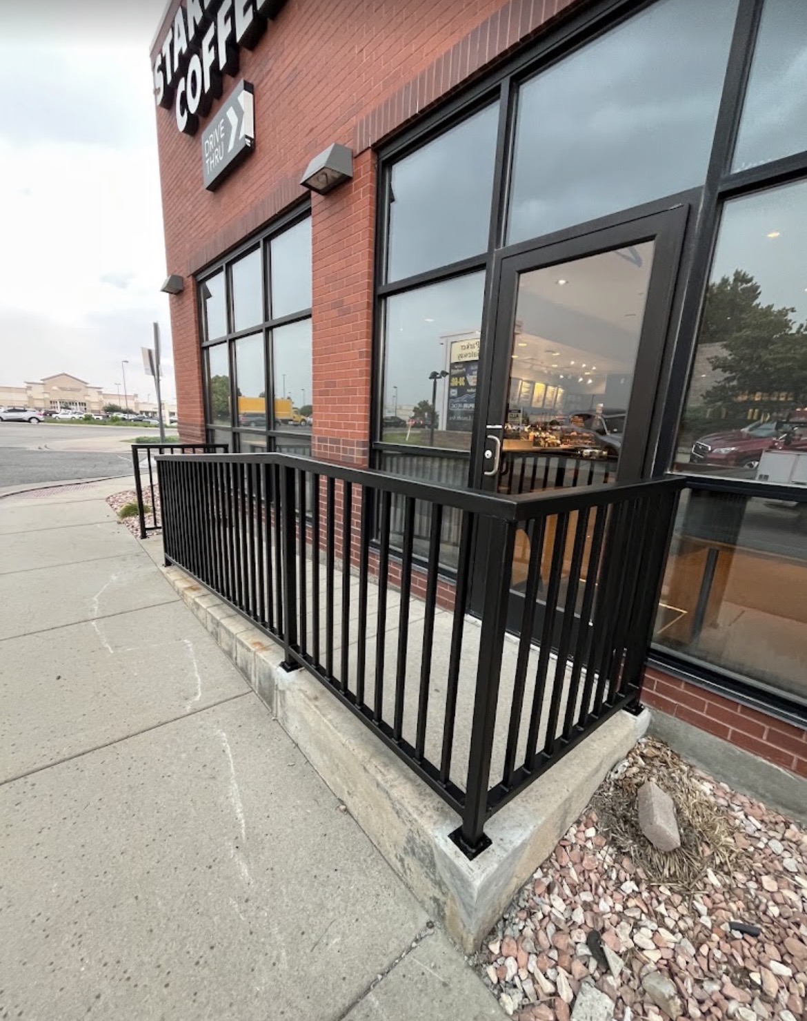 Black steel storefront railing at coffee shop patio