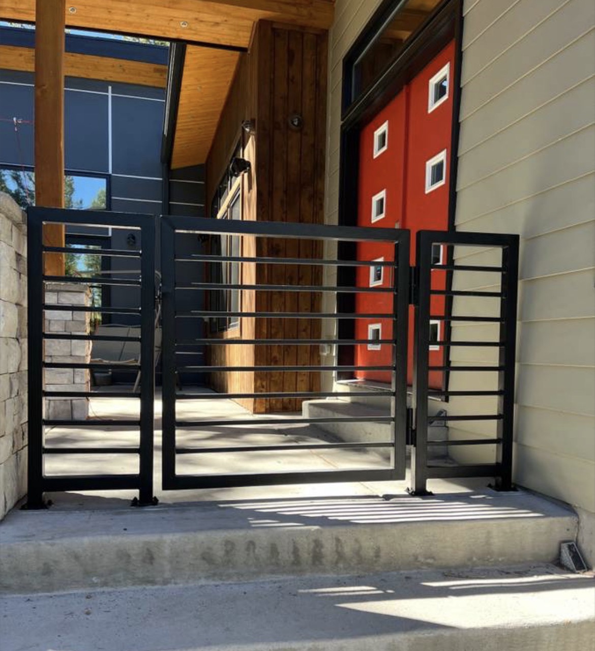 Modern horizontal-bar steel entry gate at contemporary home