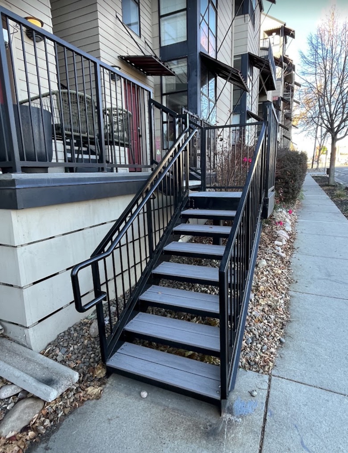 Black steel stairway and porch railing at apartment sidewalk